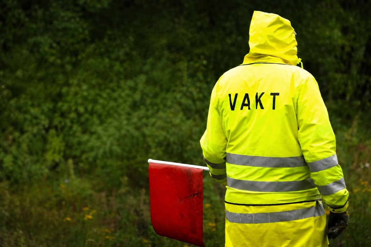 Flaggvakt som dirigerar trafiken vid ett vägarbete i Uppsala